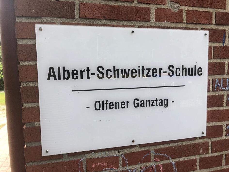 Schild der Albert-Schweitzer-Schule mit der Aufschrift „Offener Ganztag“ auf einer Backsteinmauer.